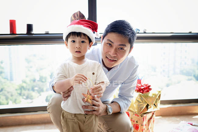 Щасливий азіатський батько і син святкують Різдво разом вдома — стокове фото