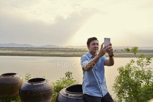 Joven tomando una selfie en el río Irrawaddy, en Bagan, Myanmar - foto de stock