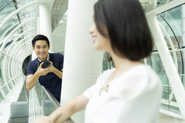 Jovem atraente asiático casal em conjunto com câmera no shopping — Fotografia de Stock