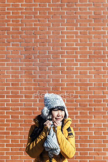 Young attractive asian woman posing against break wall — Stock Photo