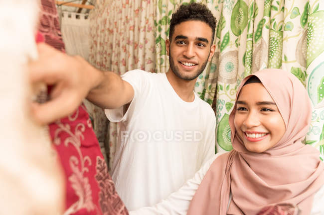 Jeune couple musulman magasinant pour des tissus dans un magasin — Photo de stock