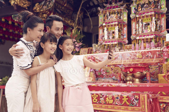 Happy asian family spending time together in traditional Singaporean shrine — Stock Photo