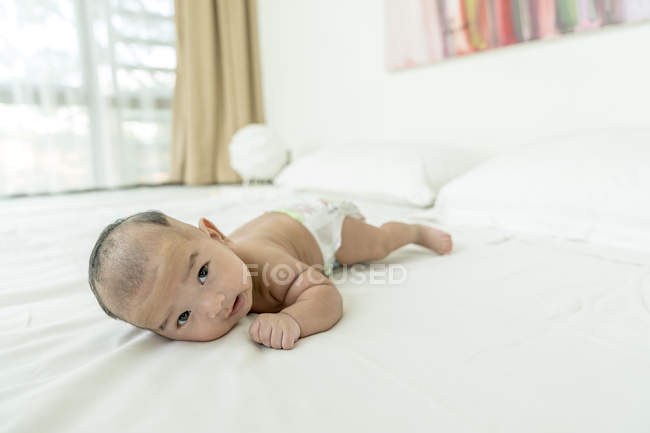 Bebê deitado de barriga para baixo em casa — Fotografia de Stock