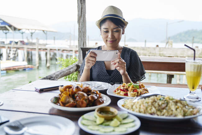 UNTERNEHMEN Junge Touristin fotografiert ihre Mahlzeit in Koh Chang, Thailand — Stockfoto