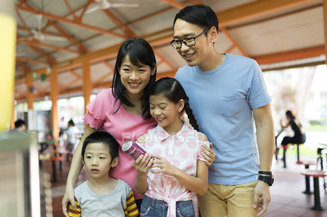 LIBERTAS Joven asiática familia juntos mirando soda agua - foto de stock