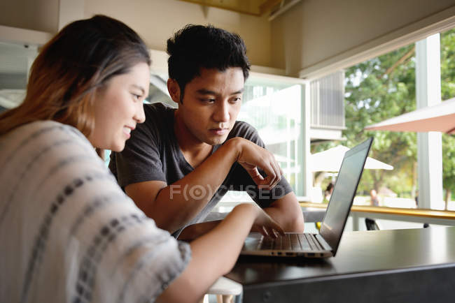 Молода приваблива азіатська пара використовує ноутбук разом — стокове фото
