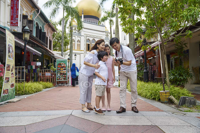 РЕЛИЗ - Счастливая молодая азиатская семья вместе путешествует по Арабской улице в Сингапуре — стоковое фото