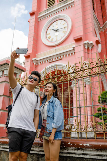RELEASES Young Vietnamese couple taking selfie in front of Tan Dinh Church, Saigon. — Stock Photo