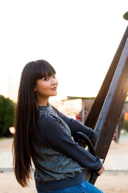 Young eurasian woman riding swing at a park in barcelona — Stock Photo