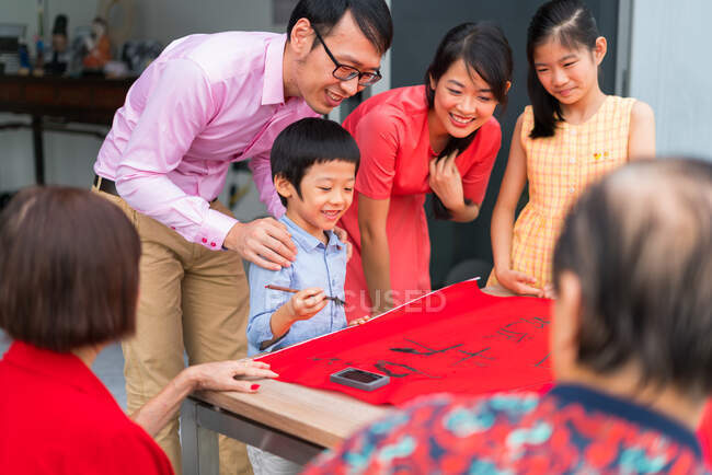 LEITUNGEN Glückliche asiatische Familie zeichnet Kalligraphie-Hieroglyphen — Stockfoto