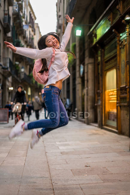 Jovem chinesa pulando e posando em Barcelona — Fotografia de Stock