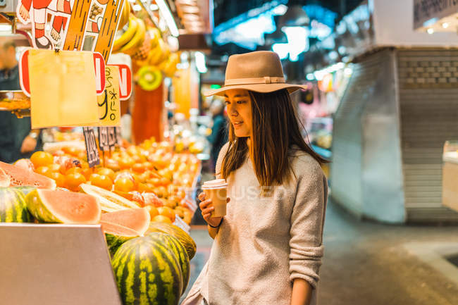 Young attractive asian woman with coffee in market — Stock Photo