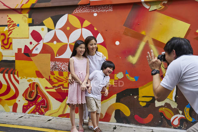 Happy young asian family together taking photo outdoors — Stock Photo