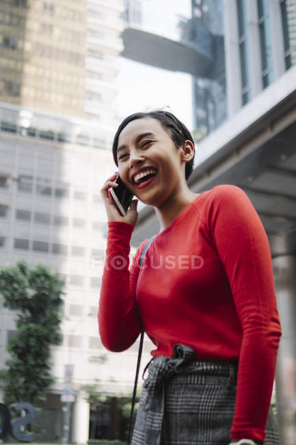 Молода азіатська приваблива жінка використовує смартфон на міській вулиці — стокове фото