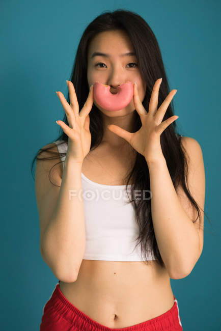 Jovem chinesa com um Donut em casa — Fotografia de Stock