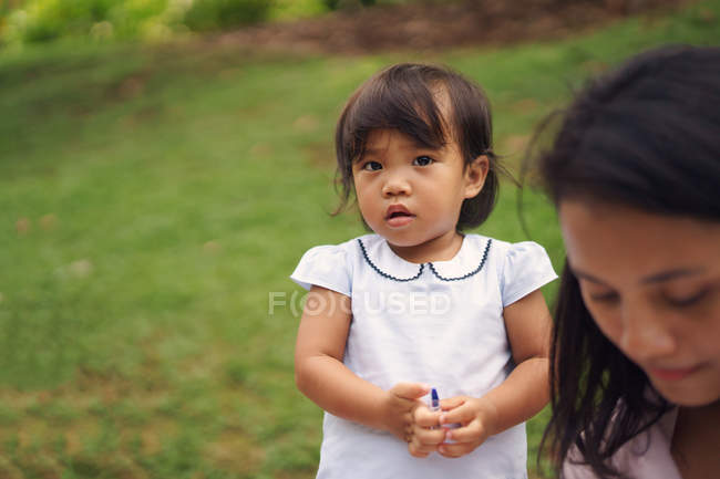 Giovane madre asiatica con carina figlioletta nel parco — Foto stock