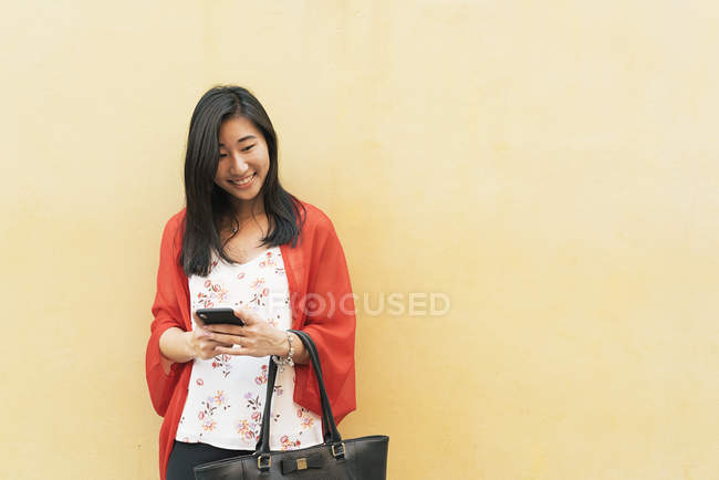 Joven feliz asiático mujer usando smartphone - foto de stock