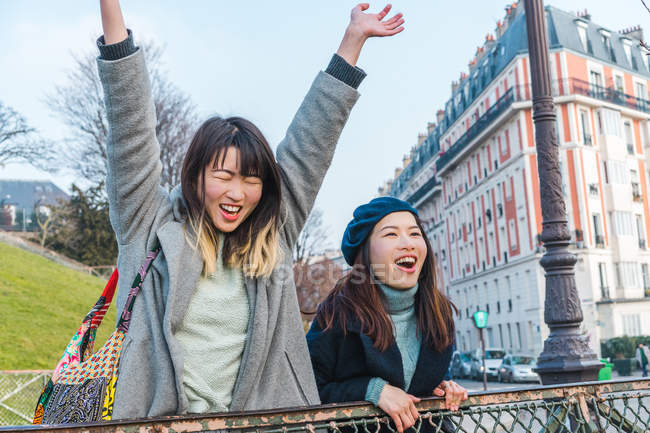 Young casual asian girls posing on city street — Stock Photo