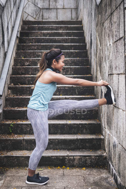 Giovane asiatica donna sportiva fare stretching nel parco — Foto stock