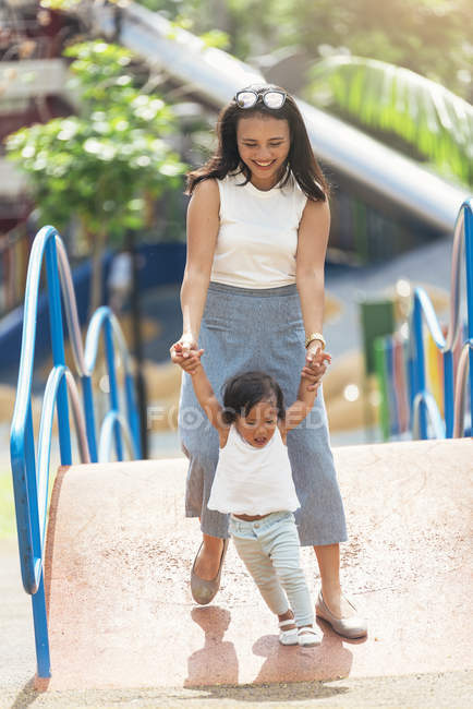 Cute adorable asian little girl in park with mother — Stock Photo