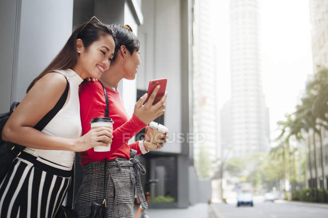 Joven asiático hembra amigos junto con café en ciudad calle - foto de stock