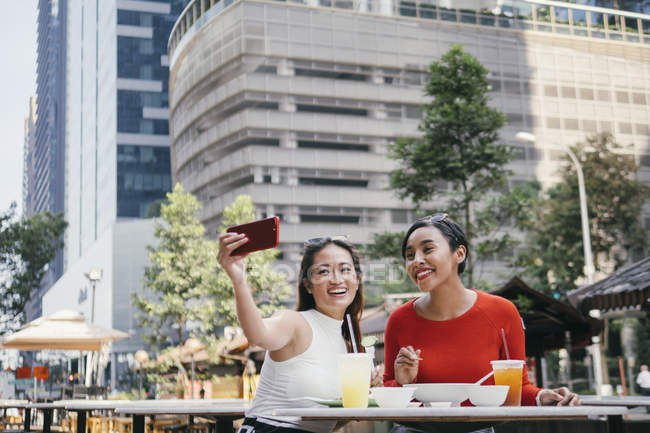 Giovani asiatico femmina amici insieme prendendo selfie in caffè — Foto stock