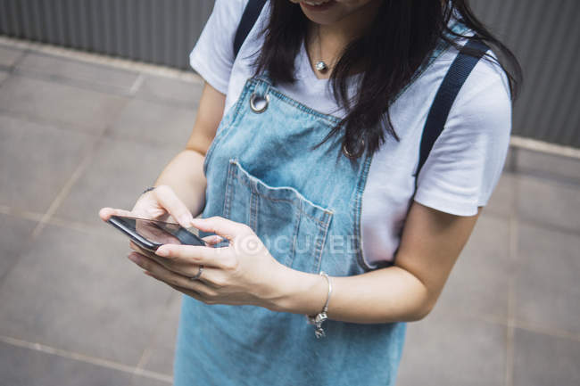 Junge asiatische College-Student mit Smartphone — Stockfoto