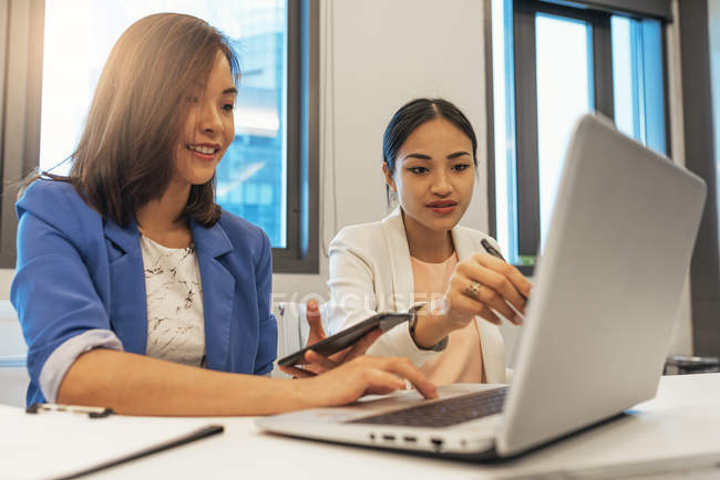 Beautiful young asian women working together in modern office — Stock Photo