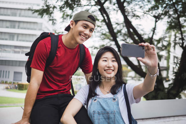 Jóvenes asiático universidad estudiantes tomando selfie juntos - foto de stock