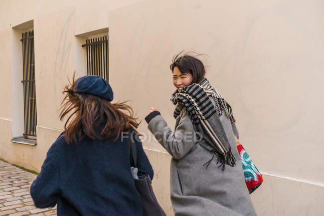 Young casual asian girls walking on city street — Stock Photo