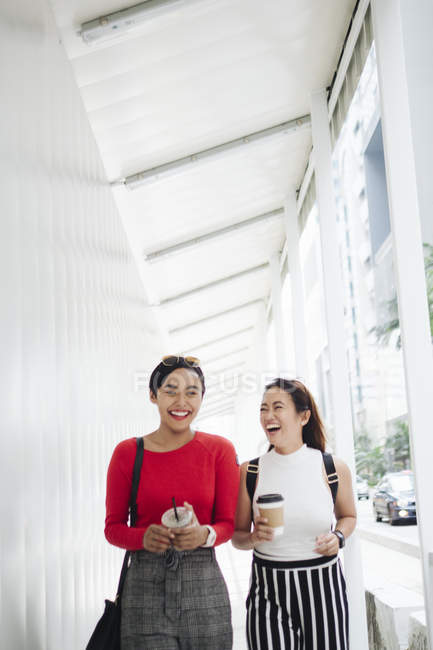 Joven asiático hembra amigos juntos caminar con café - foto de stock