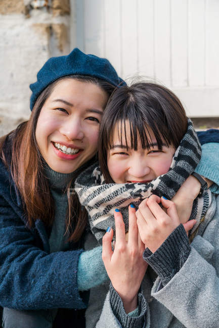Young casual asian girls hugging together — Stock Photo