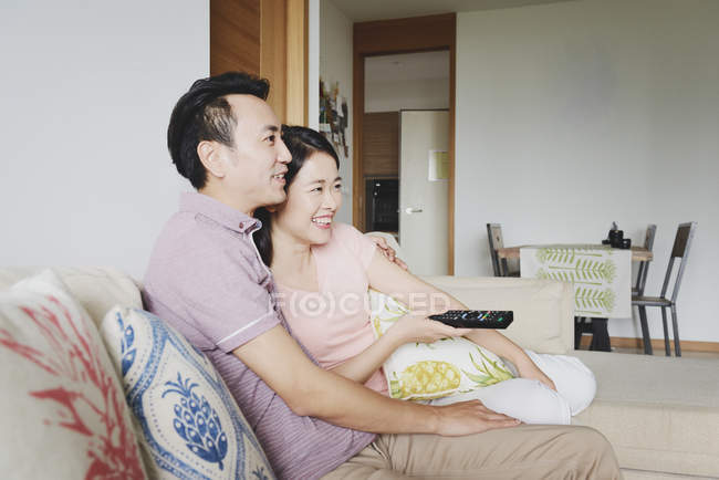 Adult asian couple together watching tv at home — Stock Photo