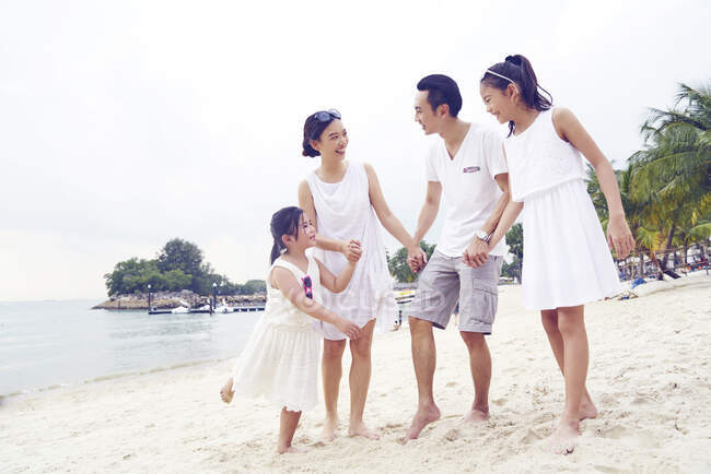 Felice famiglia asiatica trascorrere del tempo insieme sulla spiaggia — Foto stock