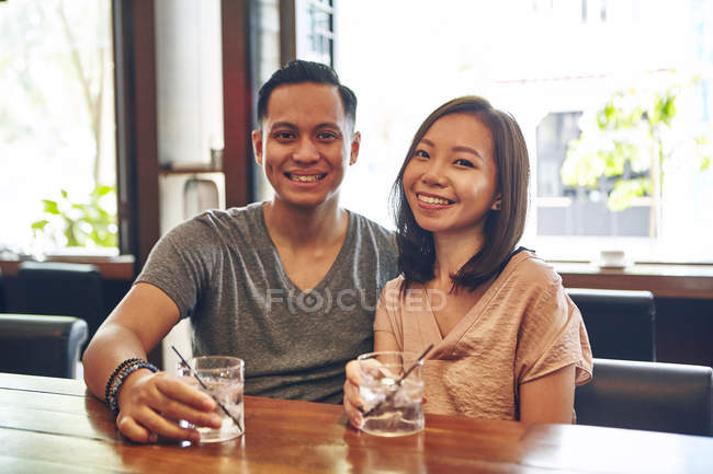Young attractive asian couple having date in cafe — Stock Photo