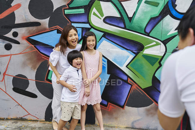Happy young asian family together taking photo outdoors — Stock Photo