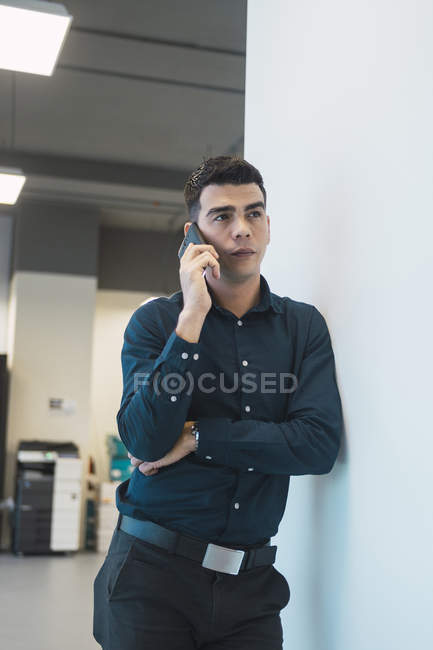 Homme d'affaires réussi parler au téléphone dans le bureau moderne — Photo de stock