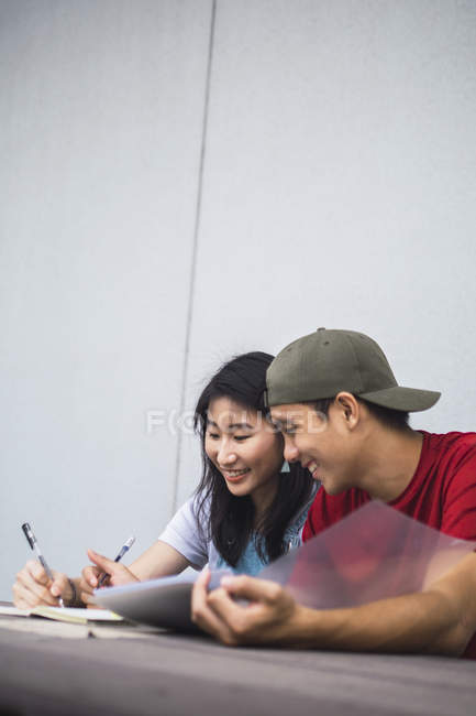 Молоді азіатські студенти коледжу навчаються разом — стокове фото