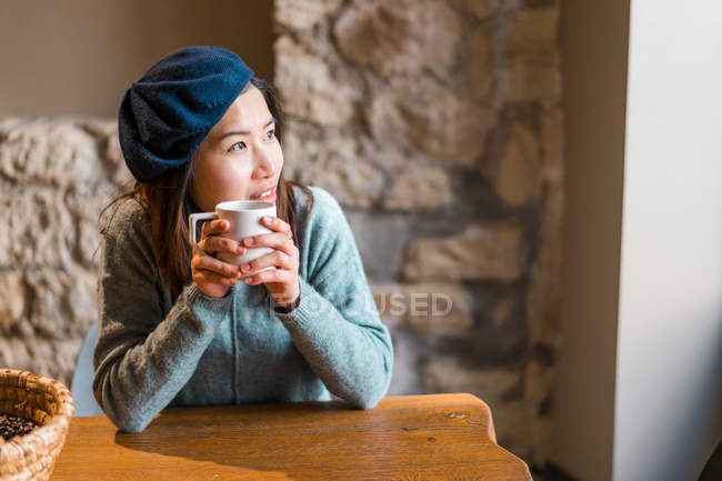Joven casual asiático chica bebiendo café en café - foto de stock