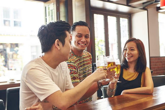 Feliz jovem asiático amigos beber cerveja no bar — Fotografia de Stock