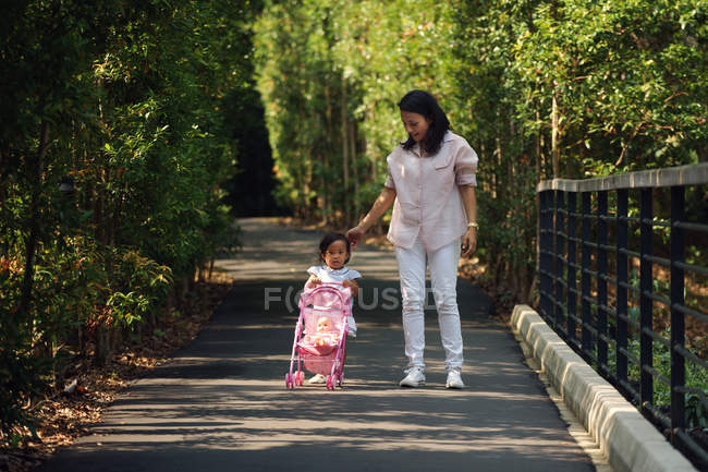 Young asian mother with cute little daughter in park — Stock Photo