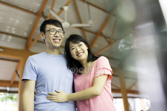 Joven pareja asiática abrazándose juntos - foto de stock