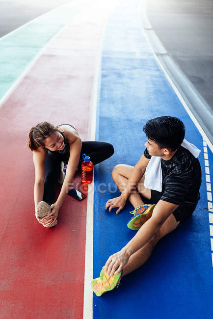 Asiatico coppia stretching insieme a stadio — Foto stock