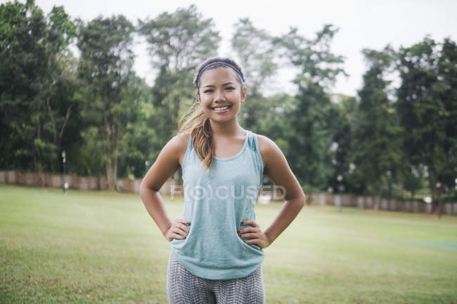 Молодая азиатская спортсменка позирует в парке — стоковое фото