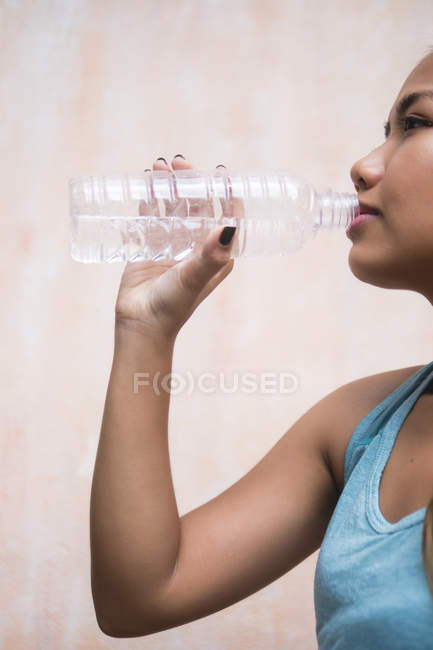 Jovem asiático desportivo mulher beber água, vista lateral — Fotografia de Stock