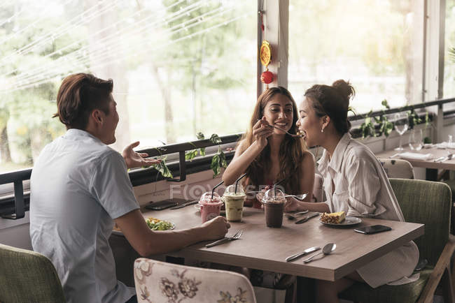 Grupo de jóvenes asiáticos amigos juntos en restaurante - foto de stock