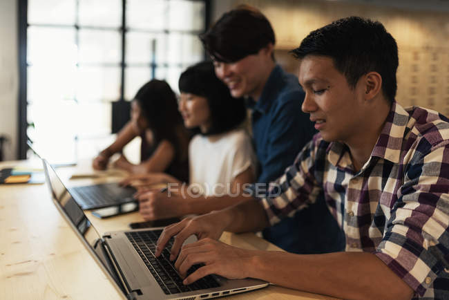 Молоді азіатські бізнесмени працюють разом в сучасному офісі — стокове фото