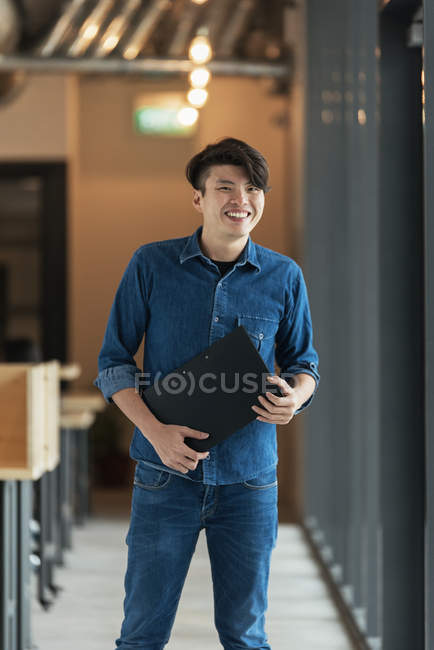 Jovem masculino asiático trabalhador com documentos no escritório — Fotografia de Stock