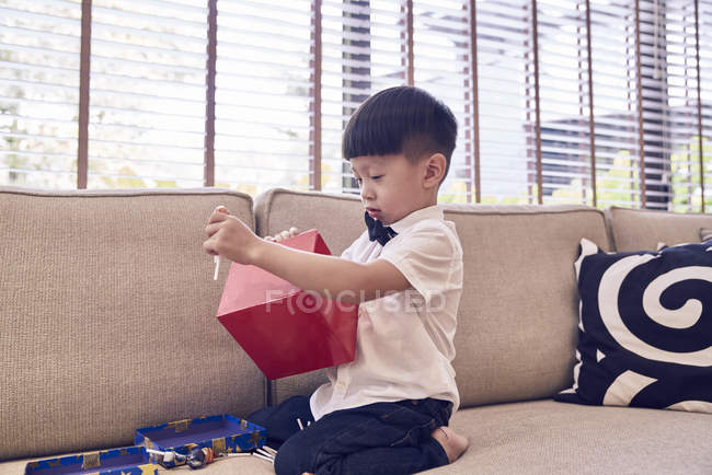 Маленький азіатський хлопчик обгортає подарунок на Різдво — стокове фото