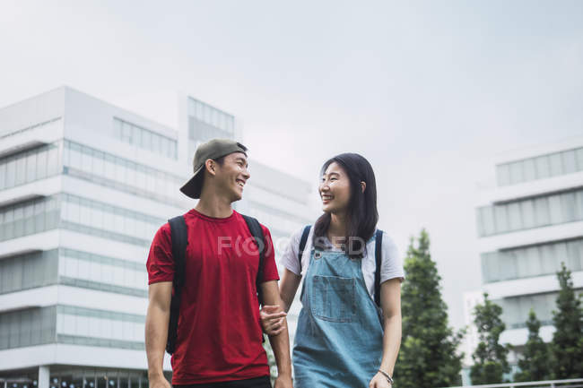 Joven asiático universidad estudiantes de pie contra campus - foto de stock